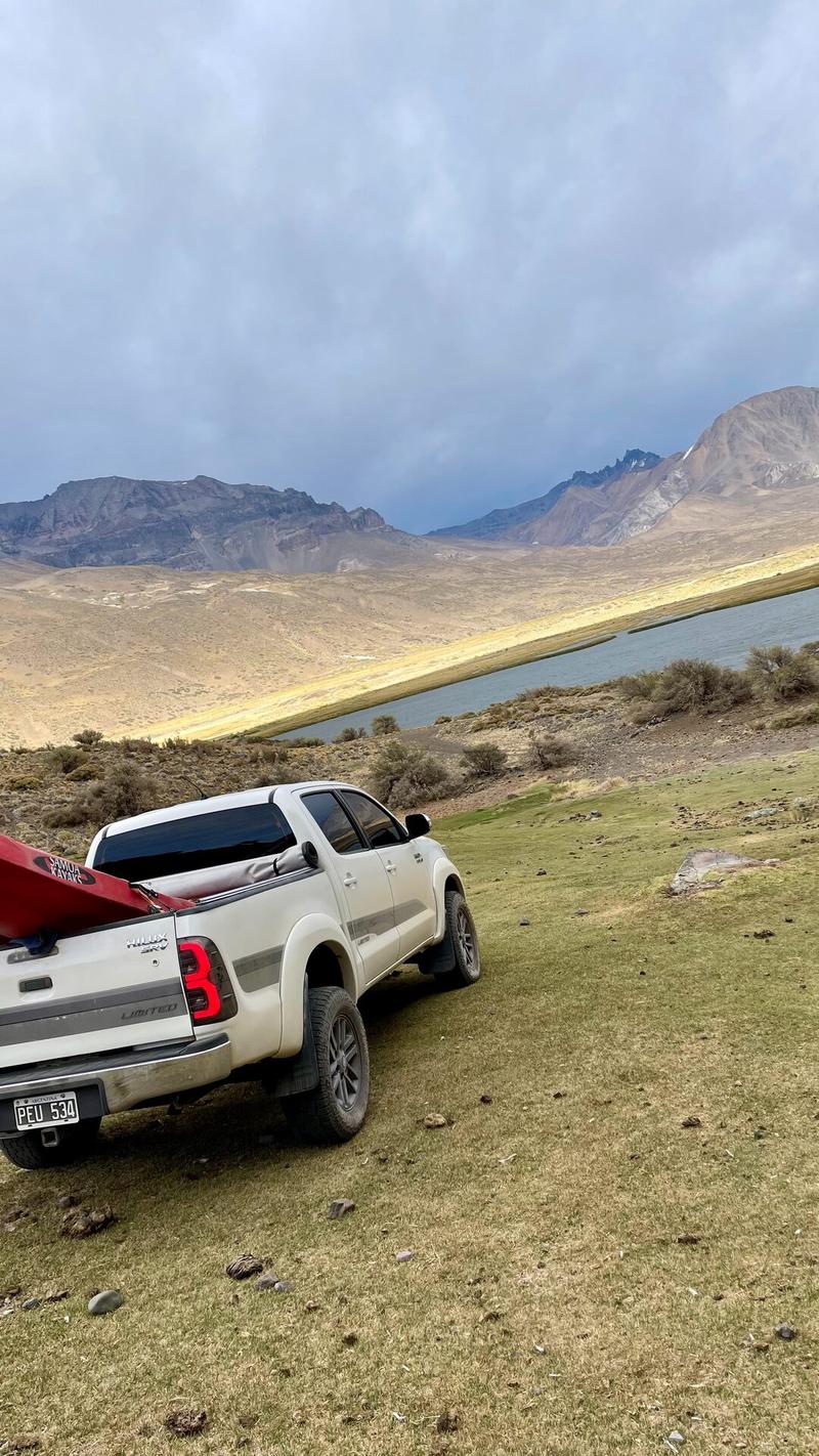 Truck loaded with a kayak beside the Los Reyunos reservoir