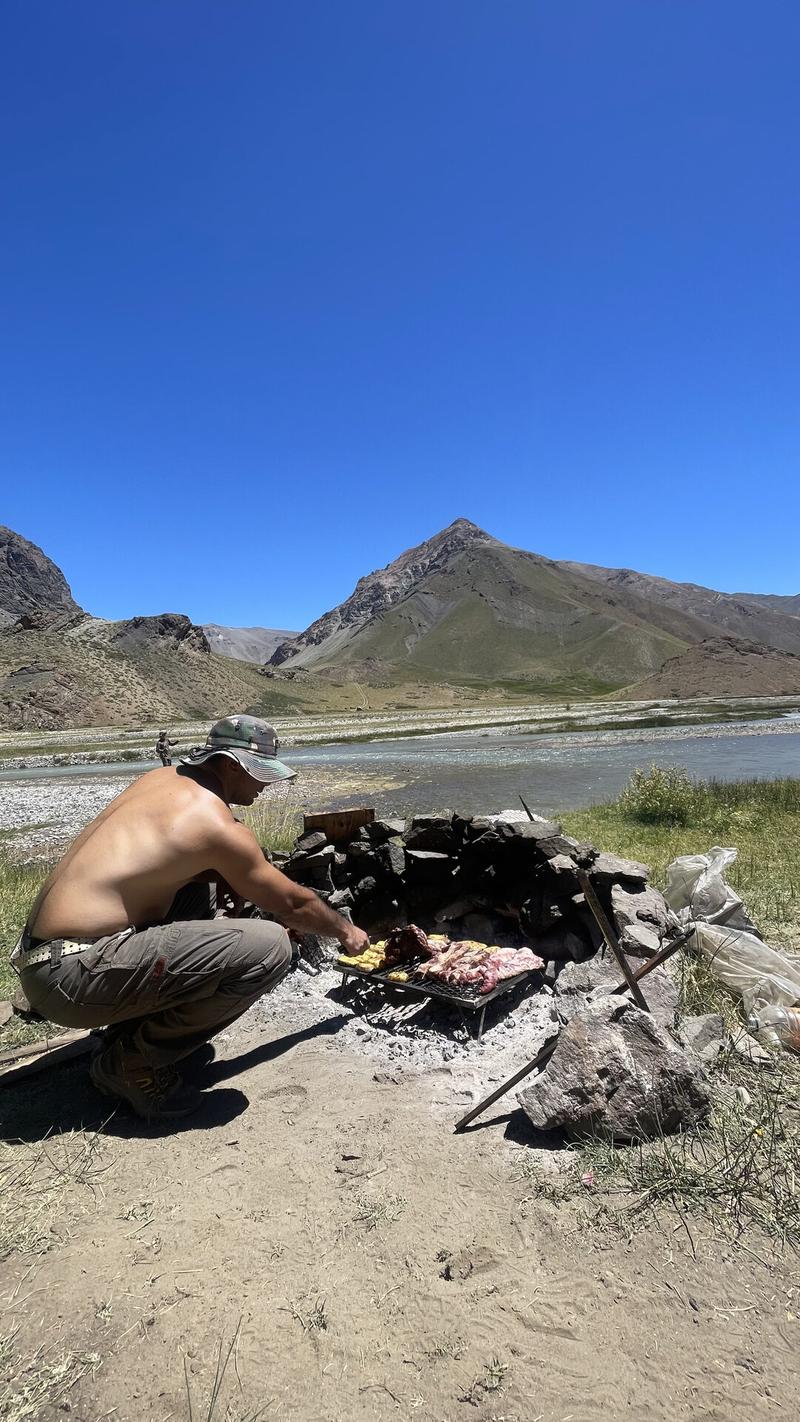 Guide grilling an asado riverside, Río Atuel